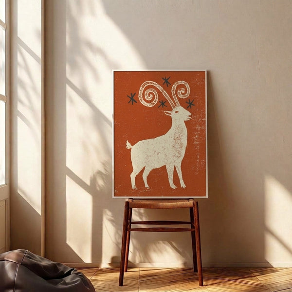 Folk art wall poster depicting a goat with sweeping horns and a star design, rendered in warm rust orange, navy, and cream with speckled texture in whimsical retro boho style.