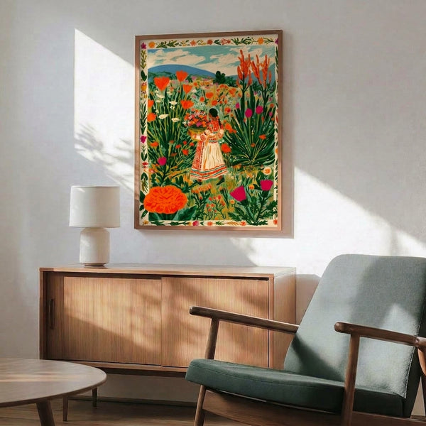 Whimsical botanical wall art showing a figure harvesting wildflowers in a sunlit meadow with mountains beyond, rendered in warm folk art style with rich orange, magenta, and forest green hues.