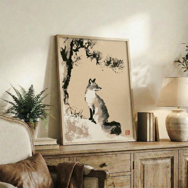 Framed Japanese-style ink painting with a fox gazing upward at birds nested in pine branches, executed in muted tan, black, and cream hues with minimalist aesthetic.