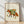 Whimsical watercolor illustration of a fox wearing a camping backpack, surrounded by wildflowers in burnt orange, forest green, and mustard yellow tones on a cream background, framed as a cottagecore-inspired art print.
