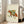 Cozy cottagecore watercolor poster featuring an adventurous fox with a packed backpack amid blooming wildflowers, rendered in warm burnt orange and earthy forest green hues.