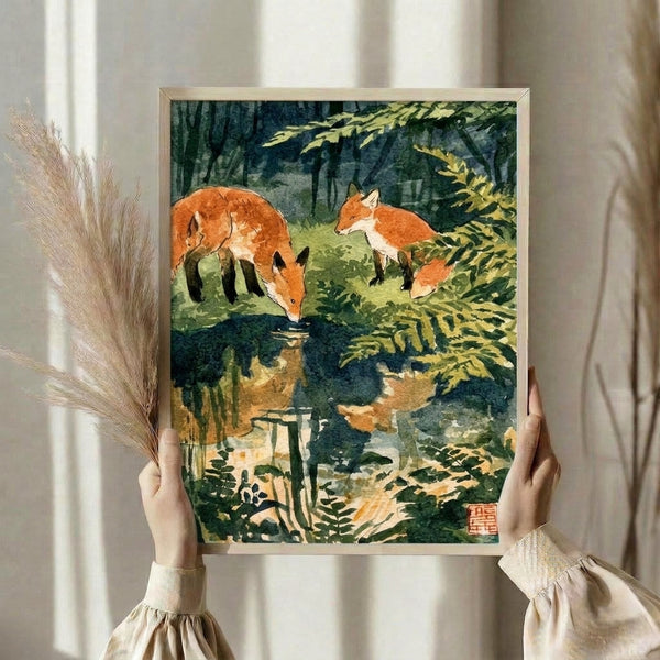 Framed vintage-style watercolor artwork featuring foxes at a woodland stream, blending naturalistic detail with Japanese artistic tradition in soft forest greens and warm orange hues.
