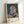 Contemporary portrait artwork with faceless abstraction in teal and ochre hues, displaying gestural expressionist technique that conveys contemplative introspection on a gallery-style wall.