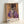 Dark expressionist poster art depicting an anguished face and hunched form in a chair, dominated by deep purples and gold accents on a cream ground.