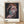 Abstract portrait with distorted facial features in rust red, pale pink, and cream tones on a dark ground, capturing an intense and introspective mood in modern art style.