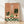 Whimsical framed poster of a relaxed frog soaking in a bubble bath surrounded by potted plants and terracotta tiles, rendered in soft sage green, cream, and olive tones in modern minimalist style.
