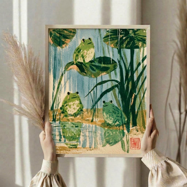 Zen-inspired framed poster featuring frogs by a water lily pond with reeds and floating plants rendered in soft, muted colors typical of Japanese woodblock art.