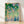 Serene watercolor poster of peach blossoms and garden foliage in soft coral, sage green, and lavender tones, rendered in an impressionist style with dreamy, peaceful atmosphere.