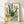 Serene watercolor painting of potted wildflowers in cream, sage green, and soft purple tones, featuring daisies and lupines in a Japandi-inspired garden composition framed on a wall.