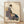 Japanese woodblock print depicting an elegant geisha in an indigo kimono holding a shamisen, paired with a male figure in traditional dress, rendered in warm cream, gold, and rust tones against a muted background.