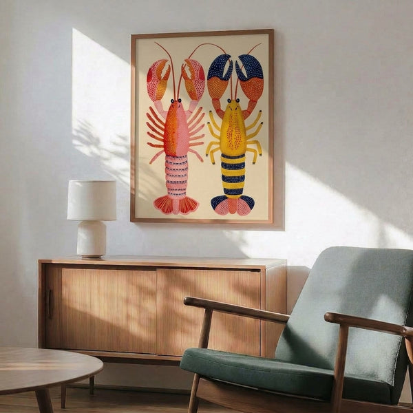 Two vibrant lobsters in playful folk art style rendered with coral red, golden yellow, and navy blue, framed as a minimalist poster bringing whimsy to any room.