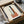 Abstract modernist poster with stacked geometric rectangles in sage green, terracotta, charcoal, and off-white, displaying serene architectural balance.