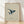 Minimalist framed poster of an origami-style whale rising through calm navy and cream waters, with warm ochre sun above in serene Japandi aesthetic.