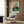 Contemporary art print with unsettling, introspective quality showing a figure and curtain cord in an abstract interior, rendered in charcoal, orange, and cream.