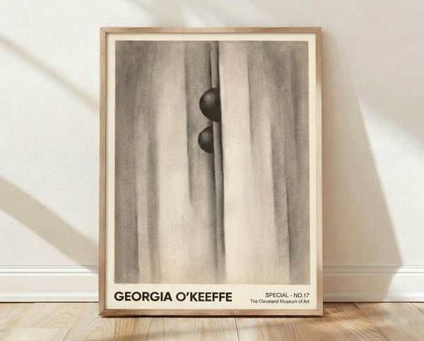 Abstract art print featuring flowing fabric and a sphere in cream, taupe, and charcoal tones, creating a mysterious and sensual composition on a framed wall.