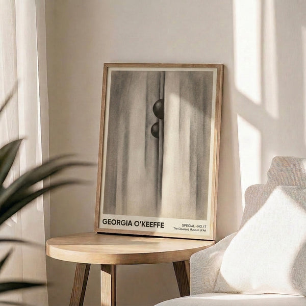 Poster art featuring abstract interpretation of fabric and sphere in neutral palette of cream, charcoal, and gray, mysterious and intimate in feeling.