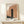 Contemporary wall art print showcasing a stark black architectural door form with serene earth tones of terracotta and cream.