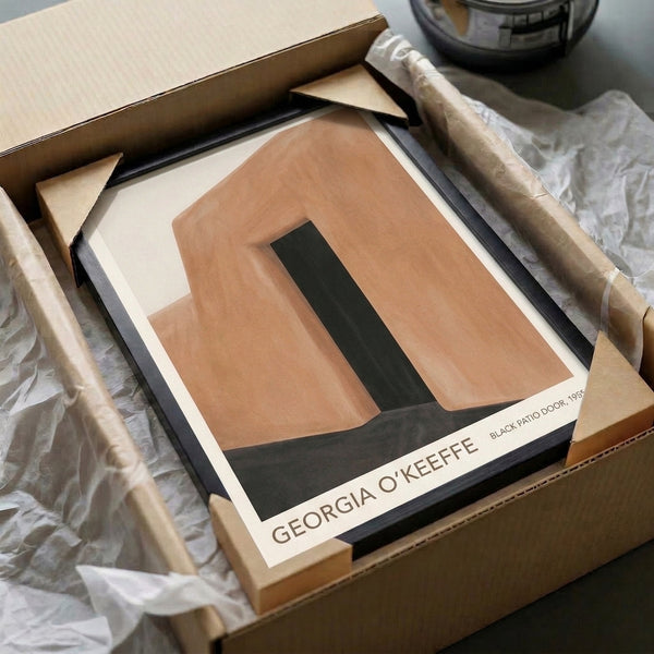Framed minimalist artwork presenting a bold black doorway form against soft terracotta and cream tones for a contemplative aesthetic.