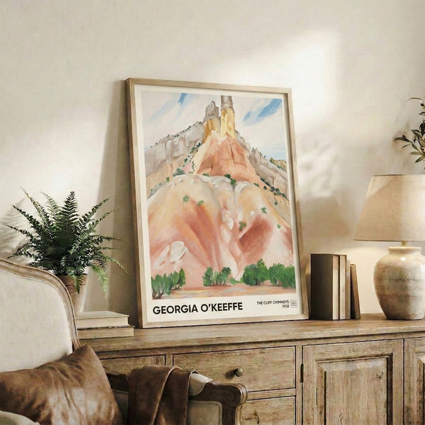 Framed vintage landscape artwork of majestic southwestern cliffs rendered in soft orange, sage green, and pale blue with contemplative impressionist style.