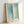 Soft abstract wall art displaying layered curved lines in pale green and pink hues with cream accents, evoking a peaceful and sensual aesthetic.