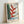 Georgia O'Keeffe's iconic heliconia artwork with soft, flowing organic forms in warm and cool tones—deep reds, forest greens, and golden yellows—displayed as a framed wall art piece.