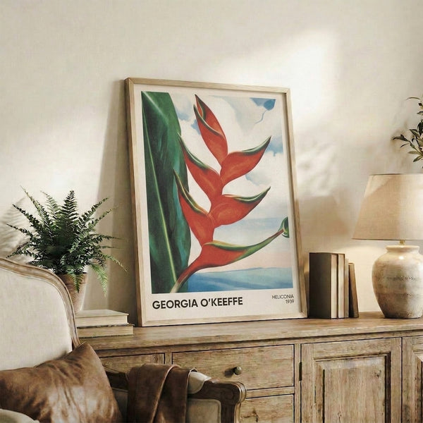 Framed poster of O'Keeffe's celebrated heliconia study, featuring bold botanical abstraction in sky blue, golden yellow, crimson, and emerald on a gallery wall.