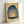 Serene abstract artwork showing soft pale yellow light radiating from a central dome shape, surrounded by deep teal and slate blue atmospheric gradients.