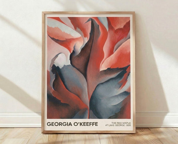 Abstract framed poster of a sensual red maple leaf rendered in deep burgundy and crimson tones against soft cream and slate blue, evoking the contemplative mood of Georgia O'Keeffe's nature studies.