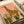 Contemporary watercolor giraffe poster in muted coral and golden tones with olive green foliage, serene minimalist design capturing the essence of the savannah.