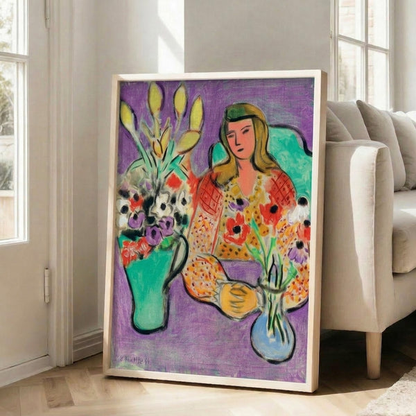 Art print on wall showing a figure amid colorful anemone blossoms rendered in soft watercolor hues on purple.