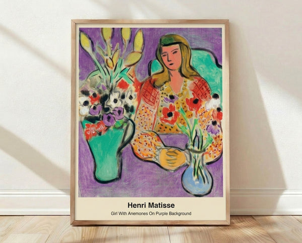 Framed modern art print featuring a girl with flowing hair surrounded by red and purple anemones on a white background in minimalist style.