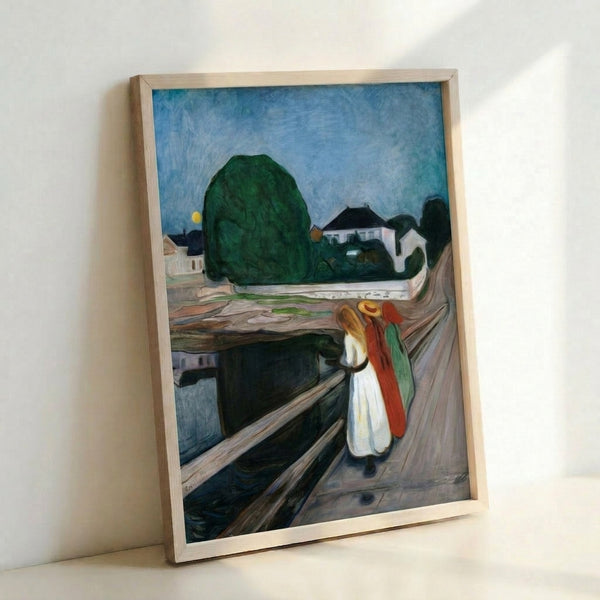 Edvard Munch's iconic Girls On The Bridge framed print showing three standing figures on a wooden pier with reflective water below, executed in expressionistic style with emotional, subdued coloring.