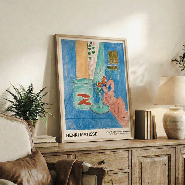 Impressionist framed poster showcasing Matisse's intimate interior with tranquil goldfish, decorative sculpture, and reclining figure in soft peachy pink and seafoam green tones.