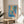Modern wall art capturing a calm, introspective moment: goldfish in a bowl, female form, sculptural piece, and flowers rendered in Matisse's characteristic cerulean and ochre palette.
