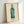 Contemporary wall art showcasing a single green bottle form in pop art aesthetic, rendered in bright green, white, and black with minimalist graphic design.