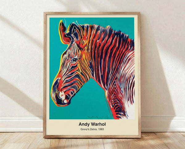 Bold pop art zebra portrait in vibrant magenta, cyan, and yellow with black outlines on white background, framed on wall.