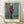Cezanne's 1880 Harlequin painting featuring a solitary figure in ochre, blue, and red tones with an introspective, melancholic mood rendered in impressionist style.