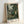 Exotic botanical jungle landscape with rich forest green and cream palette, Art Nouveau-inspired foliage composition centered around a peaceful monkey amid flowering plants and leafy branches.