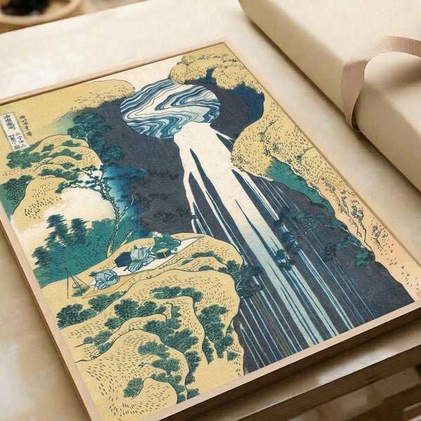 Majestic waterfall woodblock print featuring mountain scenery, travelers, and verdant slopes; framed poster in serene palette of indigo, teal, and cream tones.