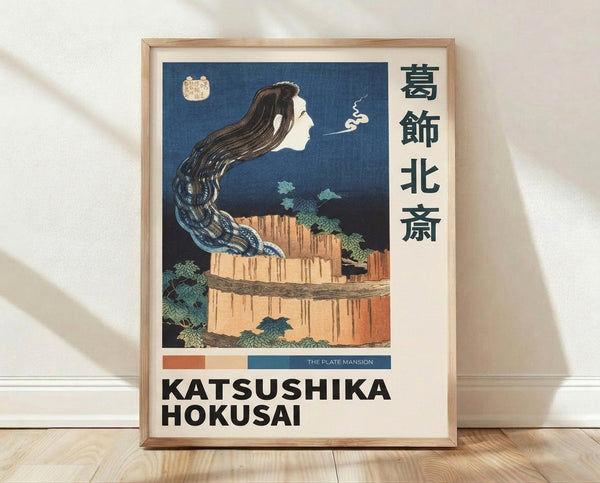 Serene Japanese woodblock print featuring a woman with long dark hair beside a cascading waterfall and misty cliffs, rendered in deep blue, cream, and terracotta tones.