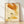 Warm minimalist poster art featuring a golden honey jar surrounded by stylized bees and delicate flowers in burnt orange, forest green, and cream tones, displayed as a framed print on a wall.