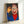 Iconic pop art print depicting a smiling figure with exaggerated features in black, red, and yellow on cream background.
