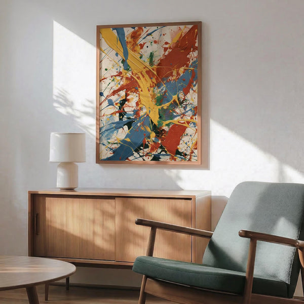 May include: Colorful abstract expressionist artwork with vibrant yellow, red, and blue paint splatters and brushstrokes in wooden frame, hanging above mid-century modern walnut credenza with white ceramic table lamp, next to sage green upholstered armchair with wooden arms in bright sunny room with white walls and natural lighting creating soft shadows.
