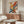 May include: Colorful abstract expressionist artwork with vibrant red, blue, yellow and orange paint splatters and brushstrokes hanging above a walnut credenza. Modern living room setting features white curved chair, glass-top coffee table, and contemporary lighting against neutral walls.