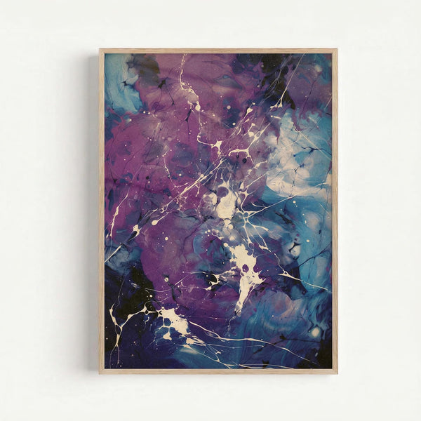 Abstract fluid art with flowing purple, blue, and teal colors blending together like liquid marble. Golden and cream colored paint splatters and thin branching lines create organic patterns across the surface. The artwork has a dreamy, cosmic appearance with small white dots scattered throughout. Displayed in a natural wood frame against a white wall.