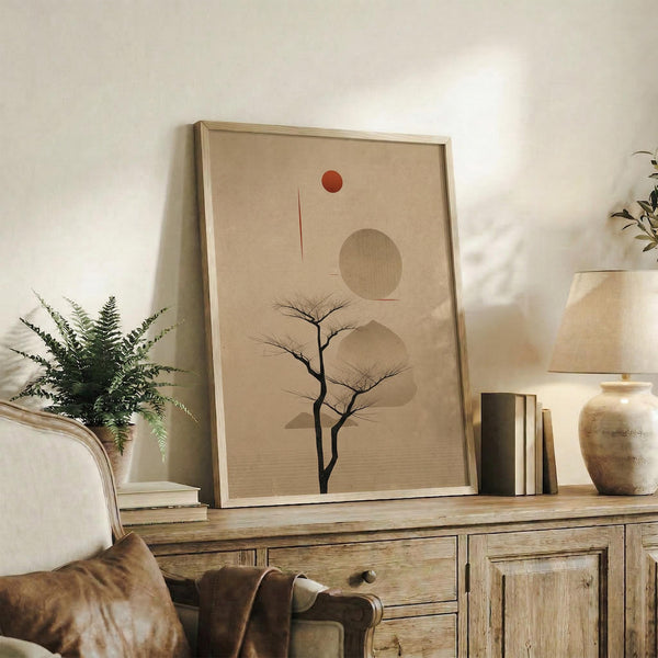 May include: Framed minimalist poster featuring a bare black tree silhouette against a beige background with geometric shapes including a red circle, large tan circle, and organic flowing forms. The artwork is displayed on a rustic wooden console beside a fern plant, pottery vase, books, and brown leather chair in a neutral-toned living room setting.