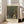 May include: Framed art print featuring Gustav Klimt's tree-lined pathway painting in golden and green tones, displayed against white walls near a beige sofa with natural lighting from large windows creating soft shadows on light wooden floors.