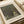 May include: Gustav Klimt art print displayed on white surface next to cream ribbon. The artwork shows a tree-lined avenue leading to yellow buildings, rendered in Klimt's distinctive style with intricate patterns and rich greens, blues, and earth tones. The print features white matting and text identifying it as a Museum of Modern Art New York piece.