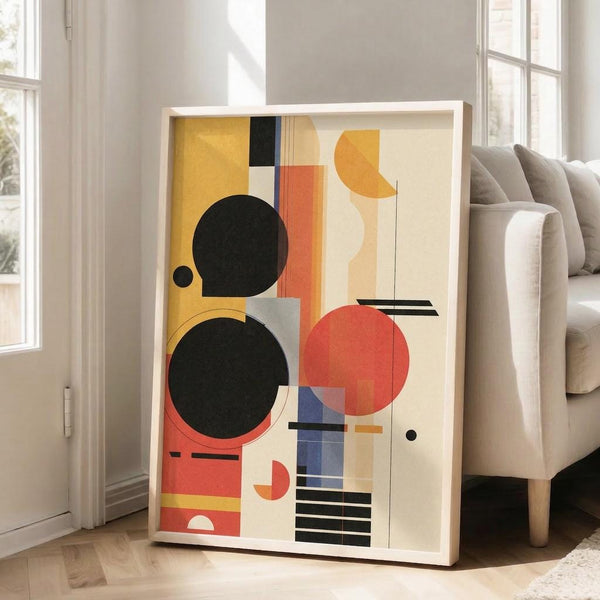 May include: Large framed abstract geometric artwork in Bauhaus style featuring black circles, orange and red shapes, blue rectangles, and yellow elements on cream background, displayed in bright living room with beige sofa, white walls, and natural light from windows