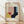 May include: Framed Bauhaus-style geometric abstract art print with overlapping shapes in muted tones of pink, yellow, navy blue, sage green, and cream. Modern minimalist poster displayed in natural wood frame, leaning against white wall on light wooden floor with soft natural lighting creating shadows.